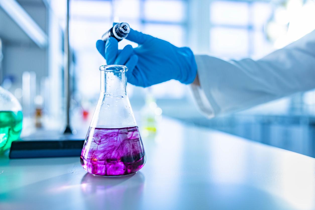 A scientist works with a beaker containing a purple liquid reminiscent of the purplish liquid plutonium that Dr. Don Mastick handled.