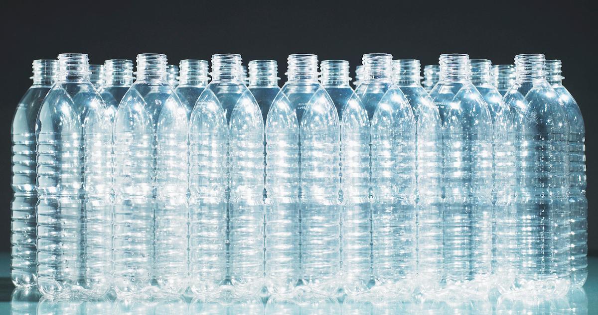 Dozens of clear plastic bottles on a surface